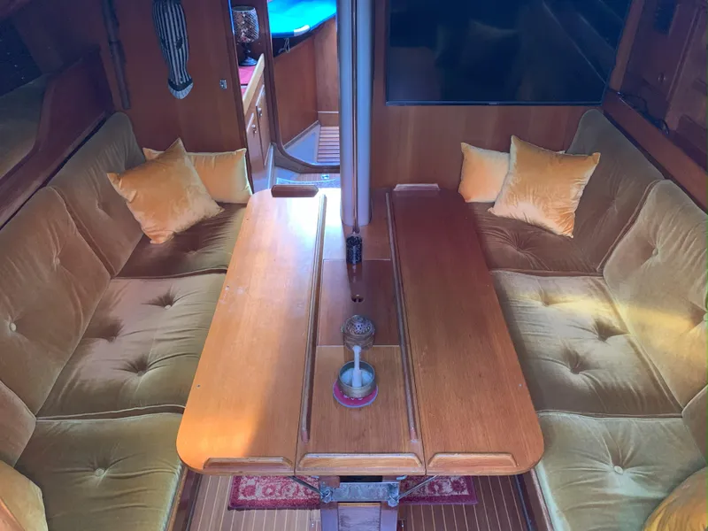Slide: The Image of Interior of 1980 Nautor Swan 371 yacht with wooden table and cushioned seating. - 13