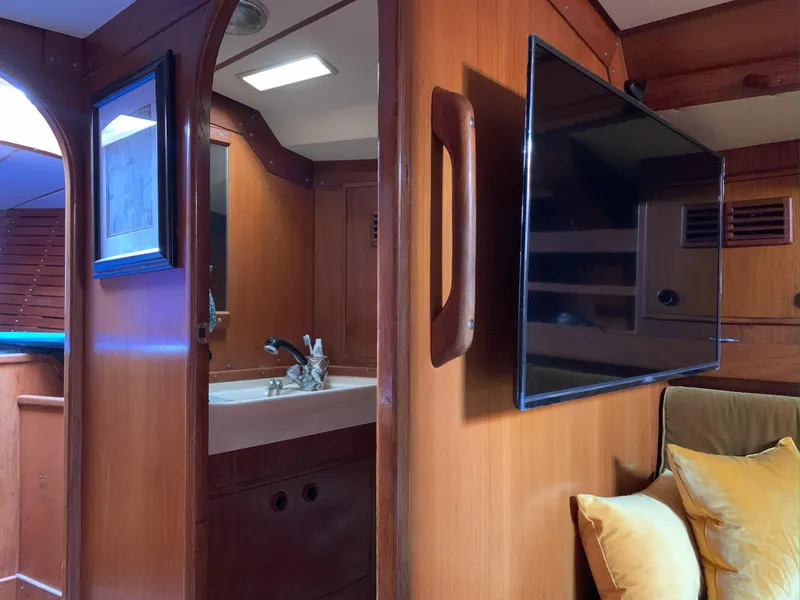 Slide: The Image of Interior of 1980 Nautor Swan 371 yacht with wooden finish, TV, and bathroom sink. - 20