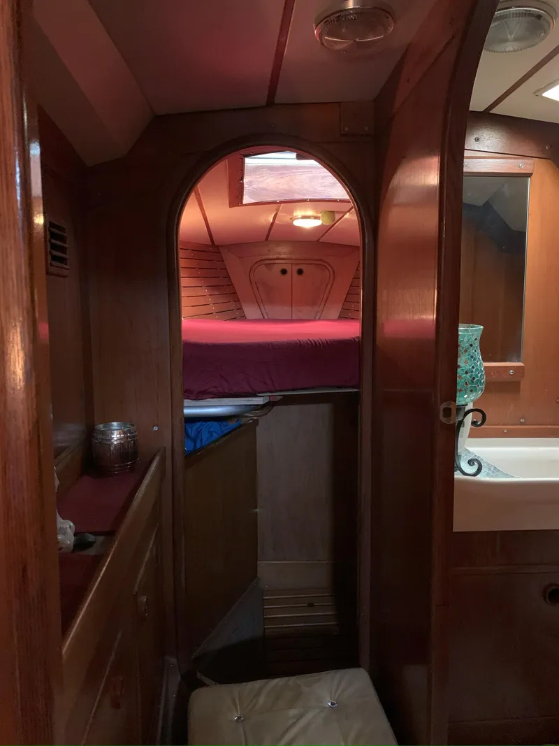 Slide: The Image of Interior of 1980 Nautor Swan 371 sailboat, featuring cozy wooden cabin and bed. - 24