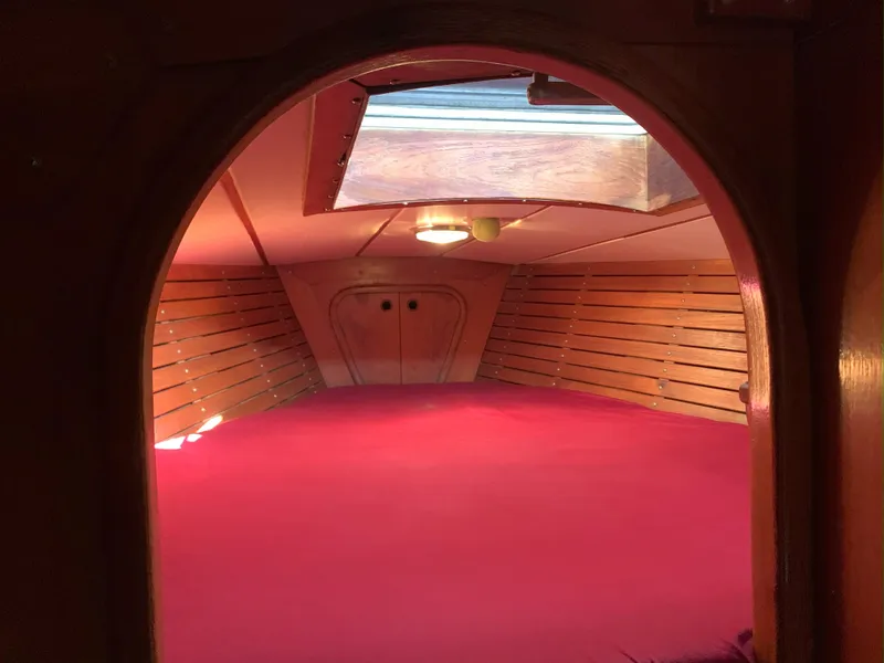 Slide: The Image of Cozy cabin interior of 1980 Nautor Swan 371 sailboat with red bedding and wooden paneling. - 25