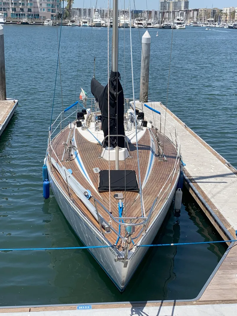 Slide: The Image of 1980 Nautor Swan 371 sailboat docked in a marina, viewed from the bow. - 3