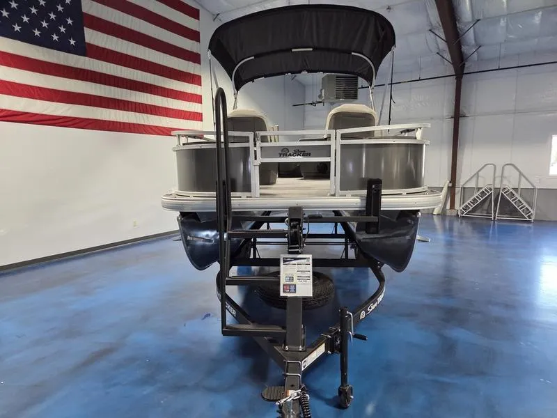 Slide: The Image of 2026 Sun Tracker BB 18 DLX pontoon boat in showroom with American flag backdrop. - 9