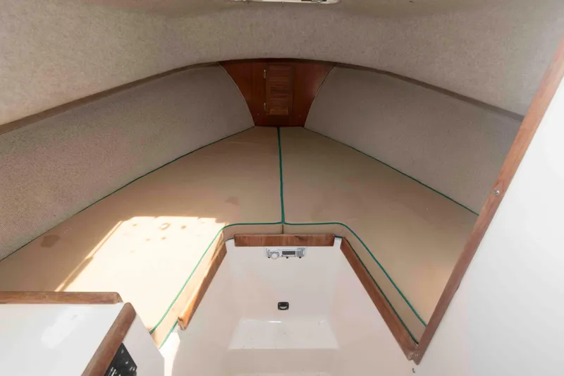 Slide: The Image of Interior cabin of 2005 Atlas Boat Works Acadia 25, featuring beige cushions and wood accents. - 12