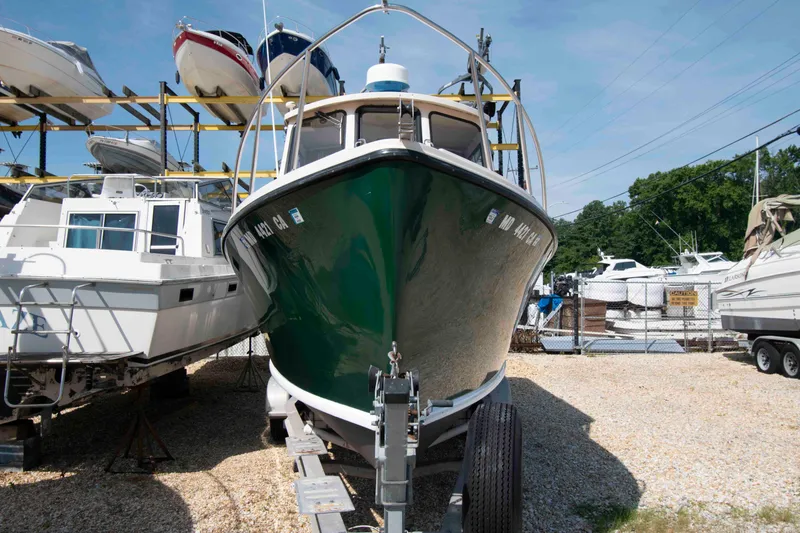 Slide: The Image of 2005 Atlas Boat Works Acadia 25 on trailer, surrounded by other boats in storage yard. - 3