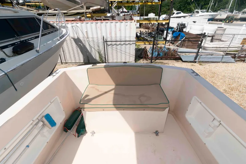 Slide: The Image of Atlas Boat Works Acadia 25, 2005 model, featuring a spacious seating area in a boatyard. - 6