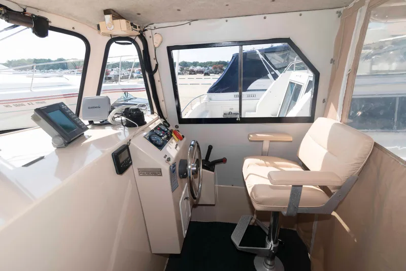 Slide: The Image of Interior of 2005 Atlas Boat Works Acadia 25, featuring helm station and seating. - 8