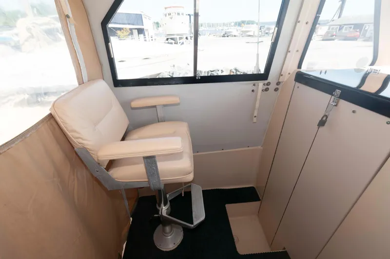 Slide: The Image of Interior of 2005 Atlas Boat Works Acadia 25, featuring a comfortable captain's chair. - 10