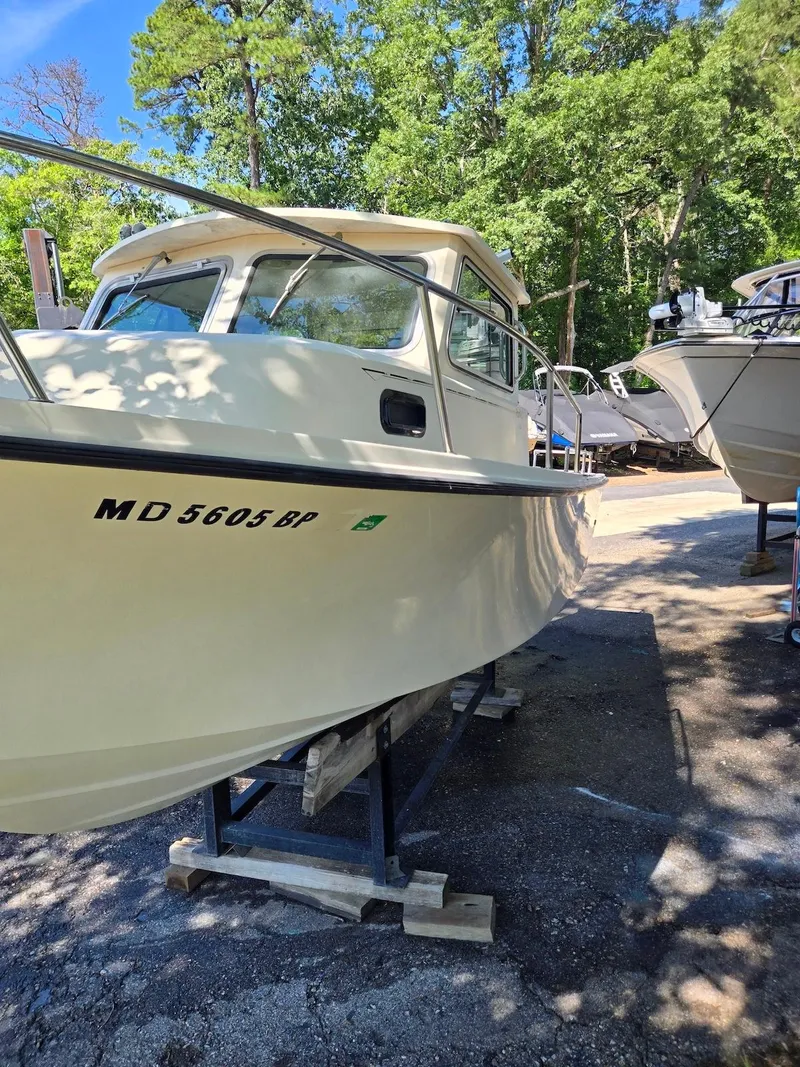 Slide: The Image of 2003 Parker 2120 Sport Cabin boat on stands, surrounded by trees. - 2