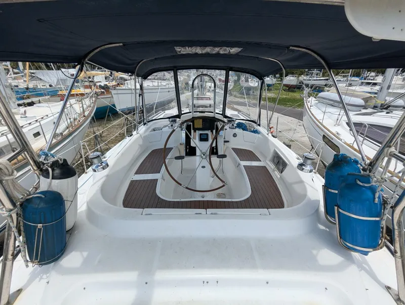 Slide: The Image of 2007 Hunter 45 Center Cockpit sailboat with spacious deck and steering wheel, docked at marina. - 16