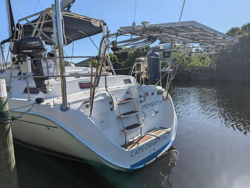 Slide: The Image of 2007 Hunter 45 Center Cockpit sailboat docked, featuring solar panels and Yamaha motor. - 23