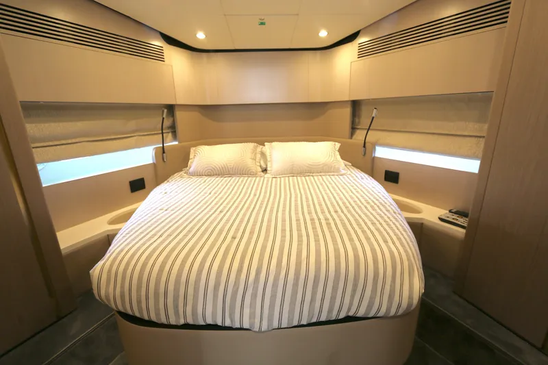 Slide: The Image of Luxurious bedroom interior of 2020 Azimut 55 yacht with striped bedding and modern design. - 11