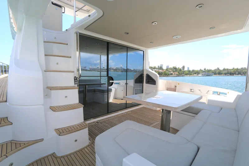 Slide: The Image of Luxurious 2020 Azimut 55 yacht deck with seating, table, and scenic waterfront view. - 14