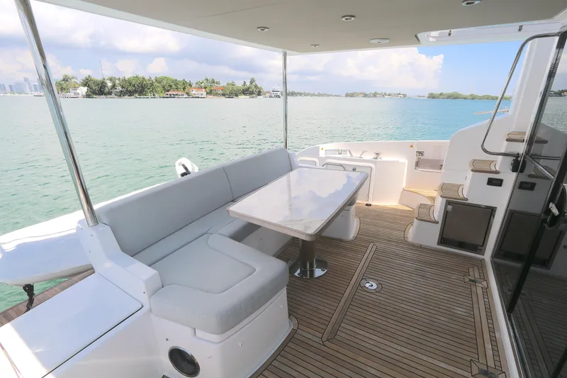 Slide: The Image of Azimut 55 yacht 2020 model, featuring a spacious deck with seating and table, overlooking serene waters. - 16