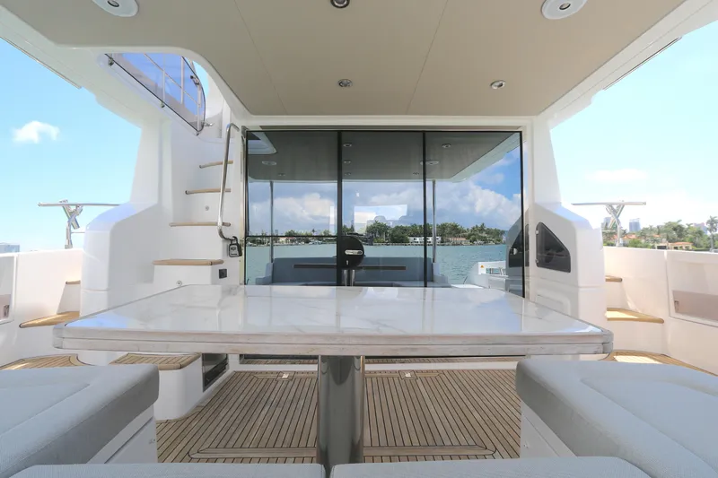 Slide: The Image of Luxury Azimut 55 yacht deck with seating and table, 2020 model, overlooking serene waters. - 17