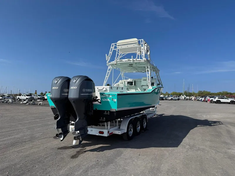 Slide: The Image of Custom 2018 Ocean Master boat with dual Yamaha engines on a trailer in a parking lot. - 11