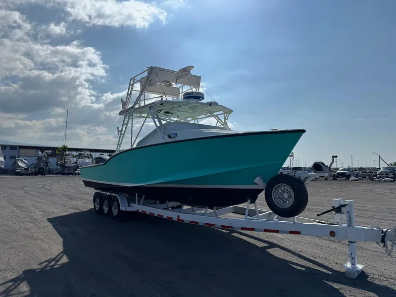 Slide: The Image of Custom 2018 Ocean Master boat on trailer under a partly cloudy sky. - 13