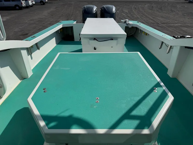 Slide: The Image of Custom Ocean Master 2018 boat deck with teal flooring and storage compartments. - 17
