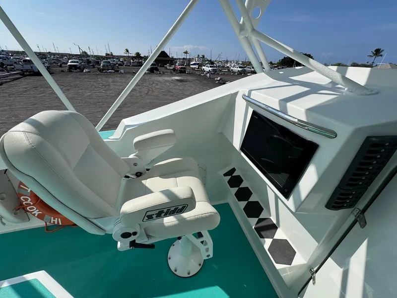Slide: The Image of Captain's chair on 2018 Custom Ocean Master boat, featuring a control panel and turquoise deck. - 18