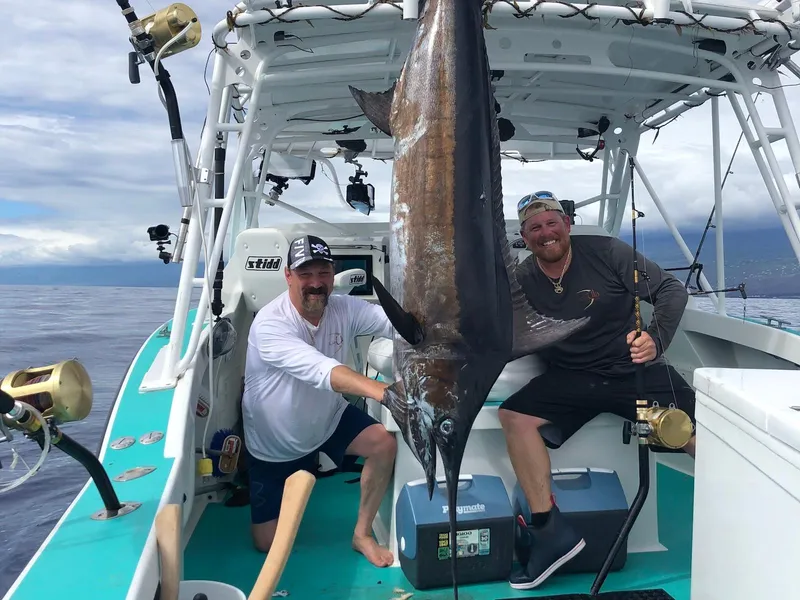 Slide: The Image of Two men on a 2018 Custom Ocean Master boat with a large marlin catch. - 21