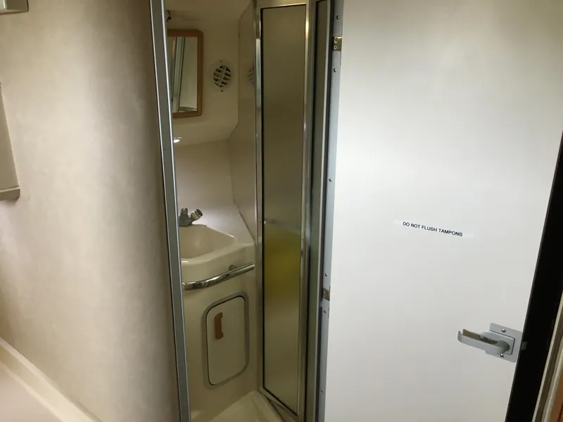 Slide: The Image of Bathroom interior of 1996 Sea Ray 400 Express Cruiser, featuring sink and mirror. - 11
