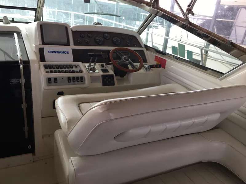Slide: The Image of 1996 Sea Ray 400 Express Cruiser helm with white seating and navigation controls. - 17