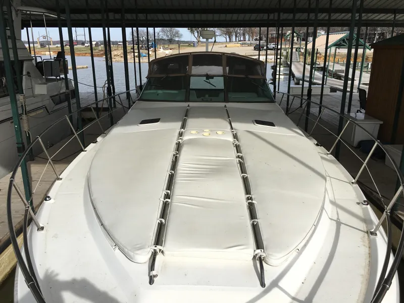 Slide: The Image of 1996 Sea Ray 400 Express Cruiser docked under a covered marina. - 18