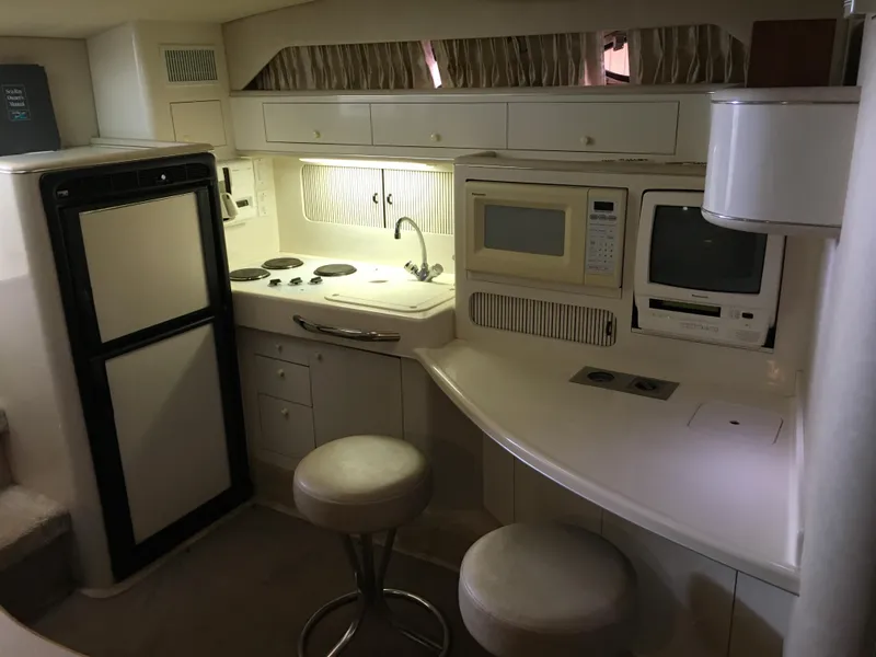 Slide: The Image of Interior of 1996 Sea Ray 400 Express Cruiser with kitchen and seating area. - 22