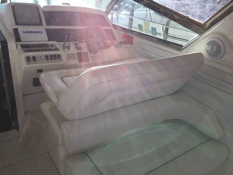 Slide: The Image of 1996 Sea Ray 400 Express Cruiser helm with white seating and control panel. - 25