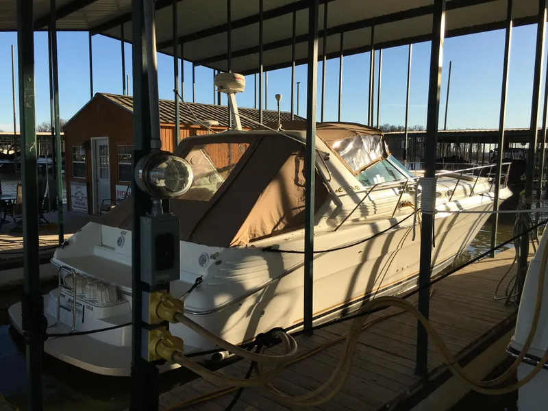 Slide: The Image of 1996 Sea Ray 400 Express Cruiser docked in a marina under a covered slip. - 27