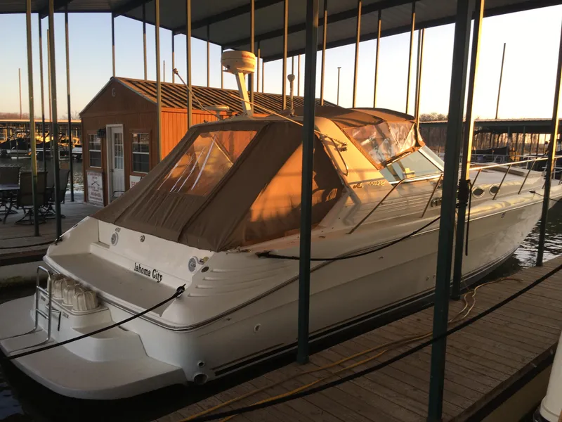 Slide: The Image of 1996 Sea Ray 400 Express Cruiser docked in a marina at sunset. - 3
