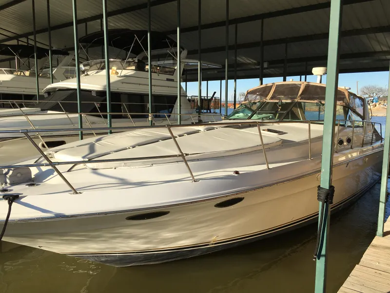 Slide: The Image of 1996 Sea Ray 400 Express Cruiser docked in a covered marina. - 34