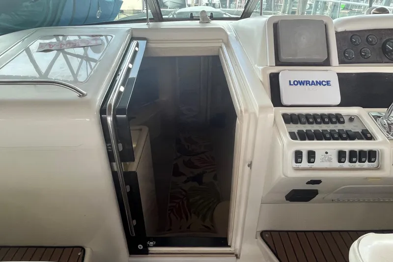 Slide: The Image of 1996 Sea Ray 400 Express Cruiser helm with Lowrance navigation system and cabin entrance. - 41