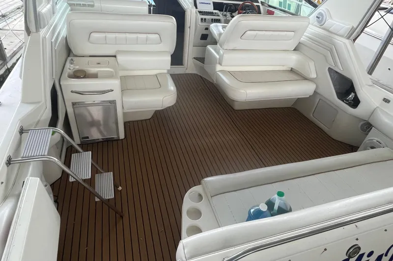 Slide: The Image of 1996 Sea Ray 400 Express Cruiser interior with white seating and wood-style flooring. - 42