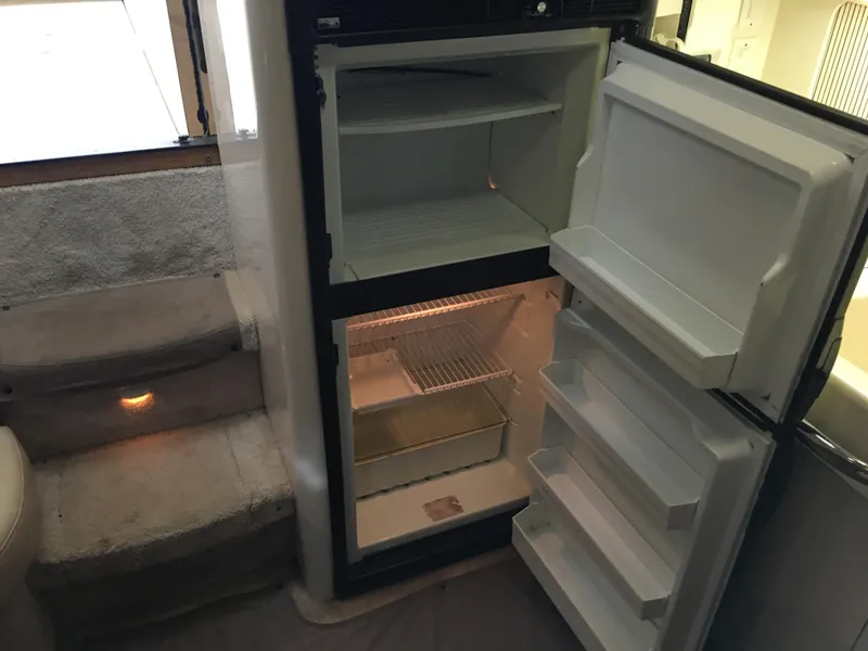 Slide: The Image of 1996 Sea Ray 400 Express Cruiser interior with open refrigerator and carpeted steps. - 9