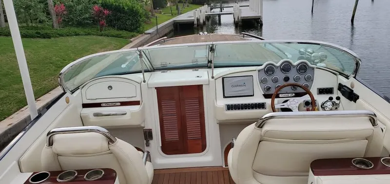 Slide: The Image of 2010 Chris-Craft Corsair 28 boat interior with dashboard, steering wheel, and seating. - 2
