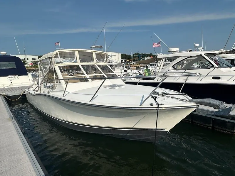 Slide: The Image of 2005 Carolina Classic 28 boat docked at marina, clear sky background. - 1