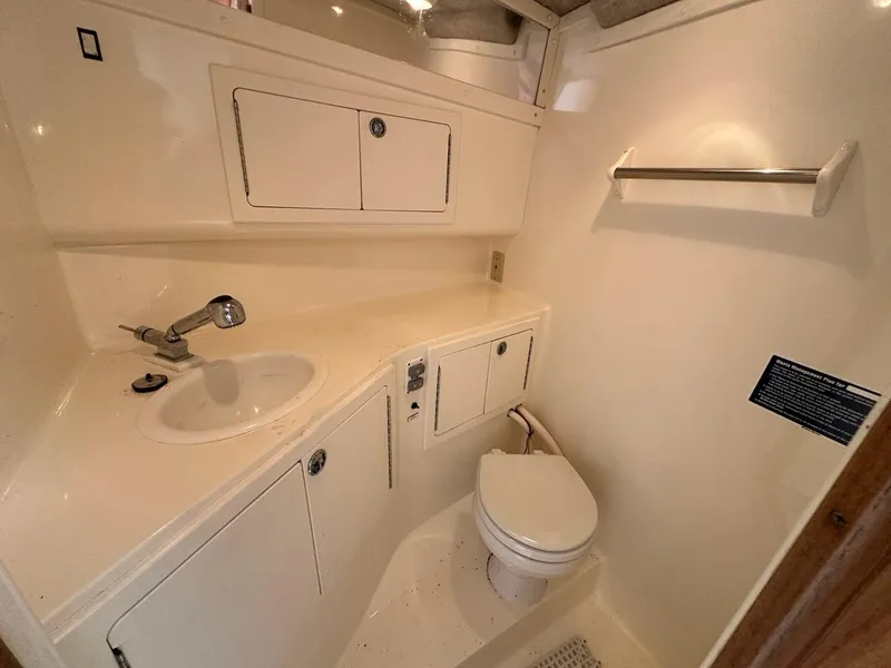 Slide: The Image of 2005 Carolina Classic 28 boat bathroom with sink, toilet, and storage cabinets. - 13