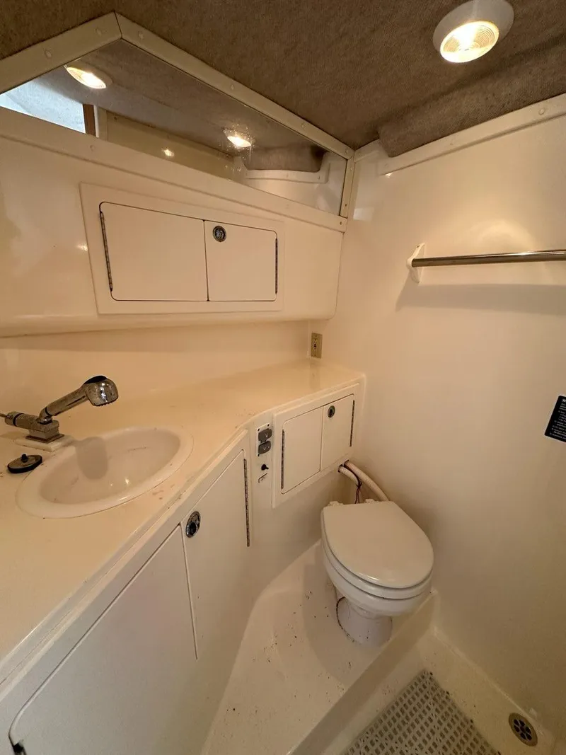 Slide: The Image of 2005 Carolina Classic 28 boat bathroom with sink, toilet, and storage cabinets. - 14