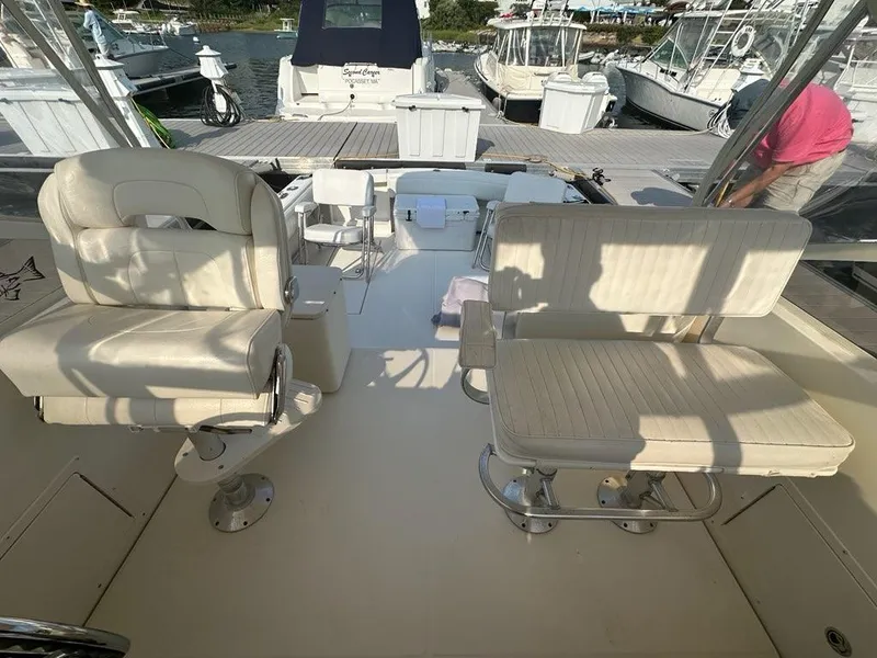 Slide: The Image of 2005 Carolina Classic 28 boat interior with cushioned seating at a marina. - 15