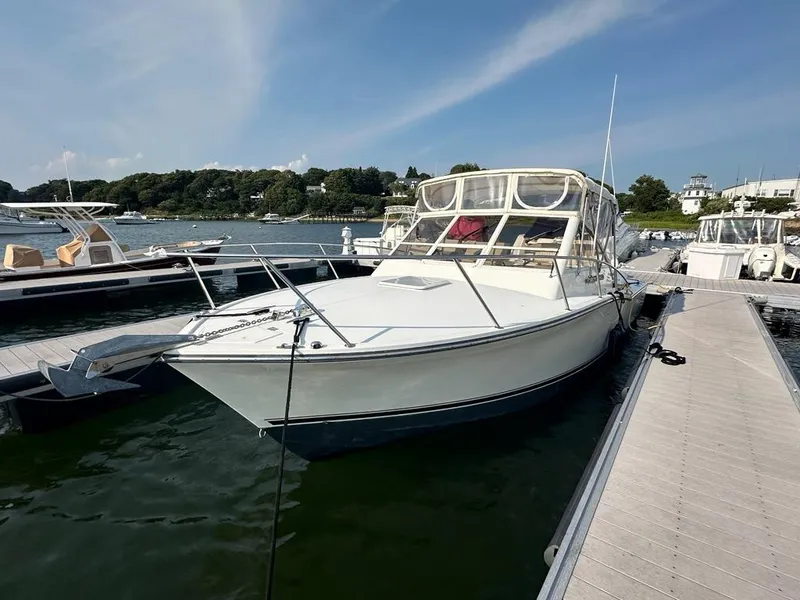 Slide: The Image of 2005 Carolina Classic 28 boat docked at a marina under a clear blue sky. - 2