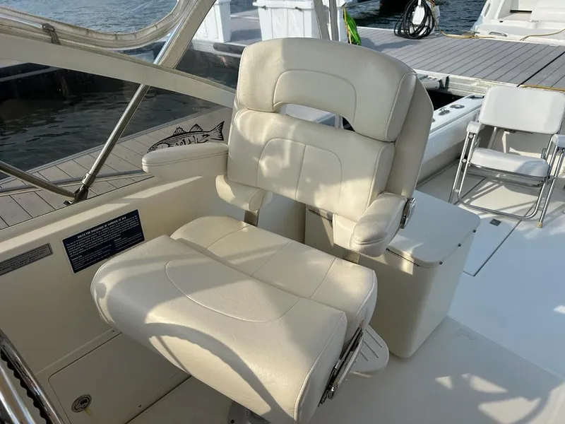 Slide: The Image of Captain's chair on 2005 Carolina Classic 28 boat, docked by the water. - 8