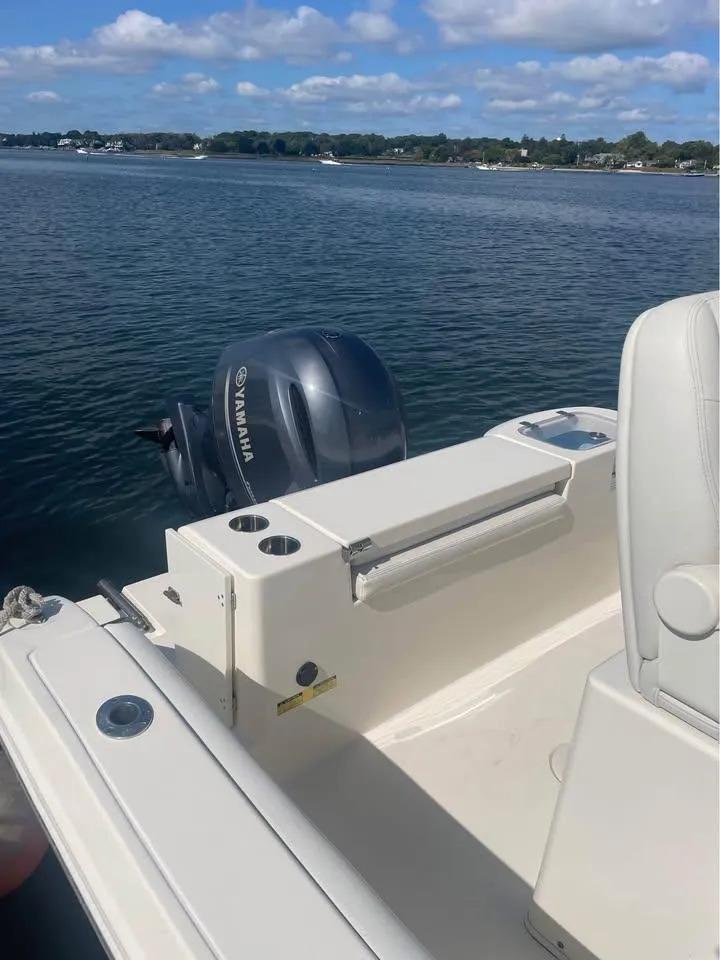 Slide: The Image of 2021 Cobia 220 Center Console boat with Yamaha engine on a calm lake. - 12