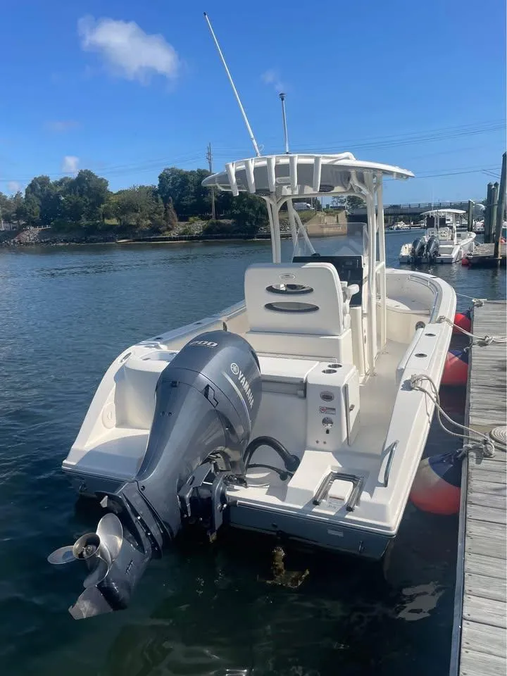 Slide: The Image of 2021 Cobia 220 Center Console boat docked with Yamaha outboard motor. - 2