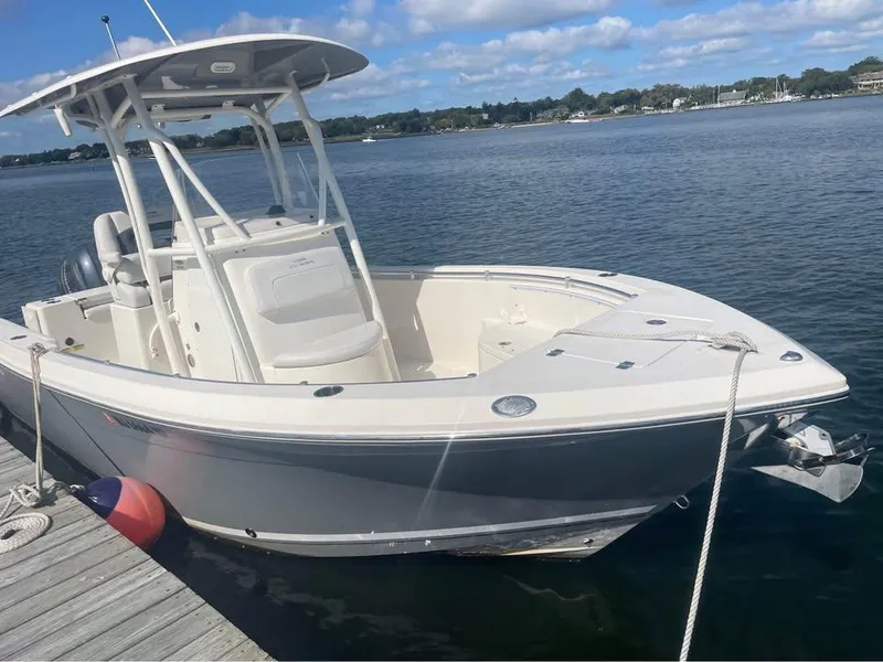 Slide: The Image of 2021 Cobia 220 Center Console boat docked on a sunny day. - 3