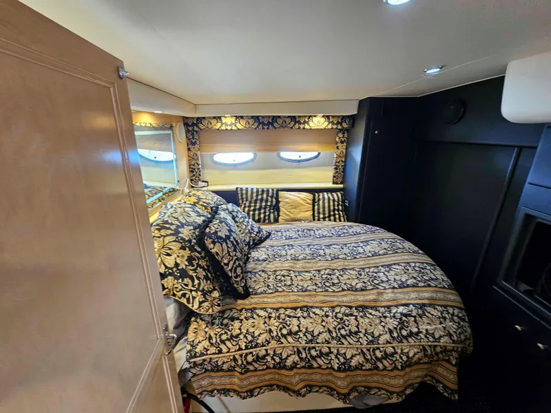 Slide: The Image of Luxurious bedroom in 2000 Carver 356 Aft Cabin Motor Yacht with elegant bedding and porthole windows. - 23