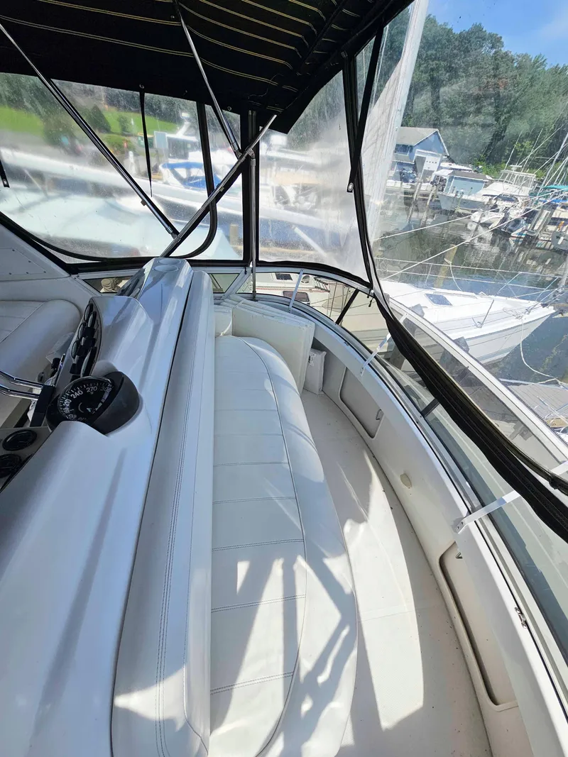 Slide: The Image of 2000 Carver 356 Aft Cabin Motor Yacht interior with white seating and helm, docked at marina. - 11