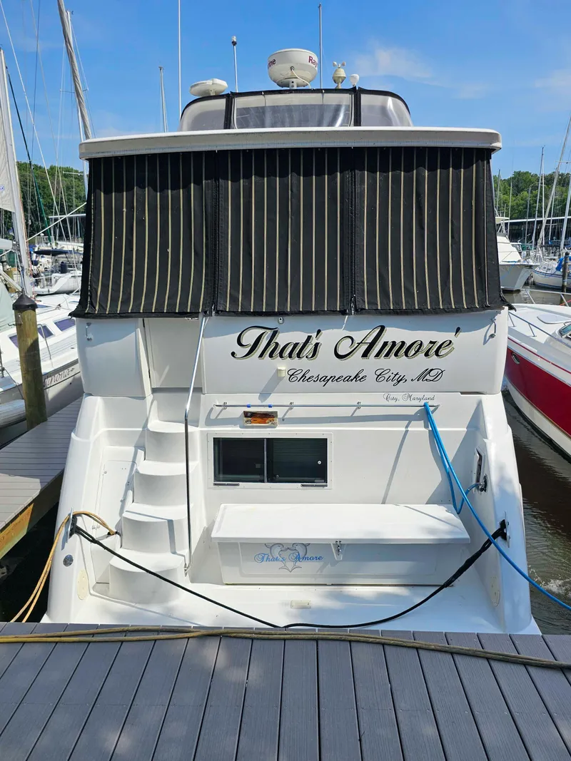 Slide: The Image of Carver 356 Aft Cabin Motor Yacht 2000 docked, rear view with "That's Amore" name. - 2