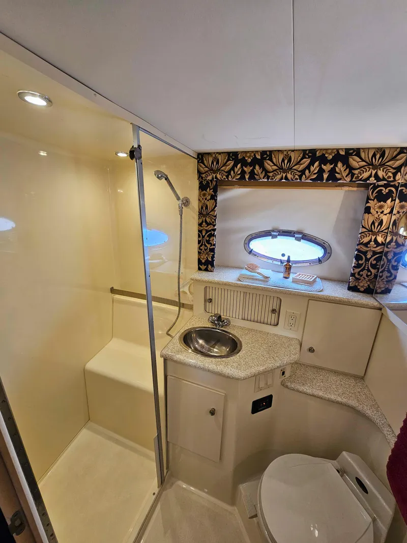 Slide: The Image of 2000 Carver 356 Aft Cabin Motor Yacht bathroom with shower, sink, and porthole window. - 24