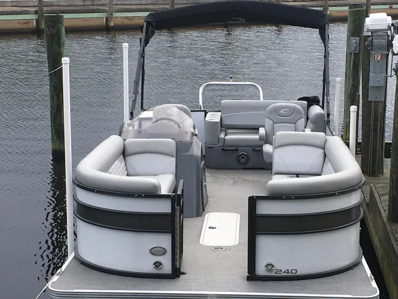 The Image of 2022 Crest Classic LX 240 pontoon boat docked, featuring spacious seating and sleek design. - 1