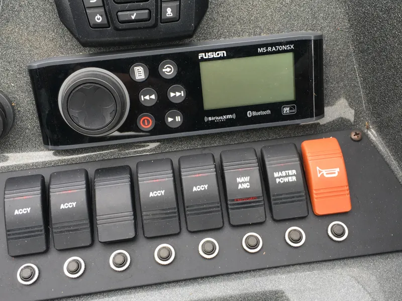 Slide: The Image of Control panel of a 2022 Crest Classic LX 240 boat with switches and a Fusion stereo. - 13